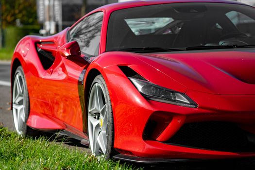 A vibrant red sports car parked on the roadside, showcasing sleek design and modern styling.
